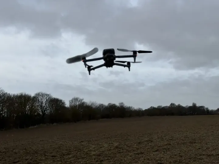 Survey drone in flight over farmland