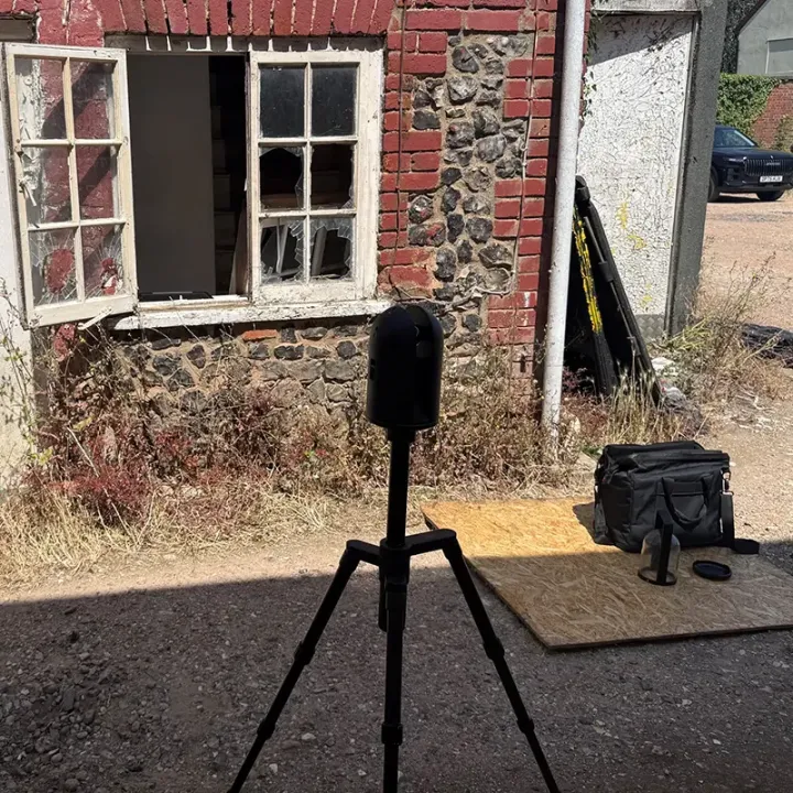 Leica BLK360 scanner outside a flint and brick cottage