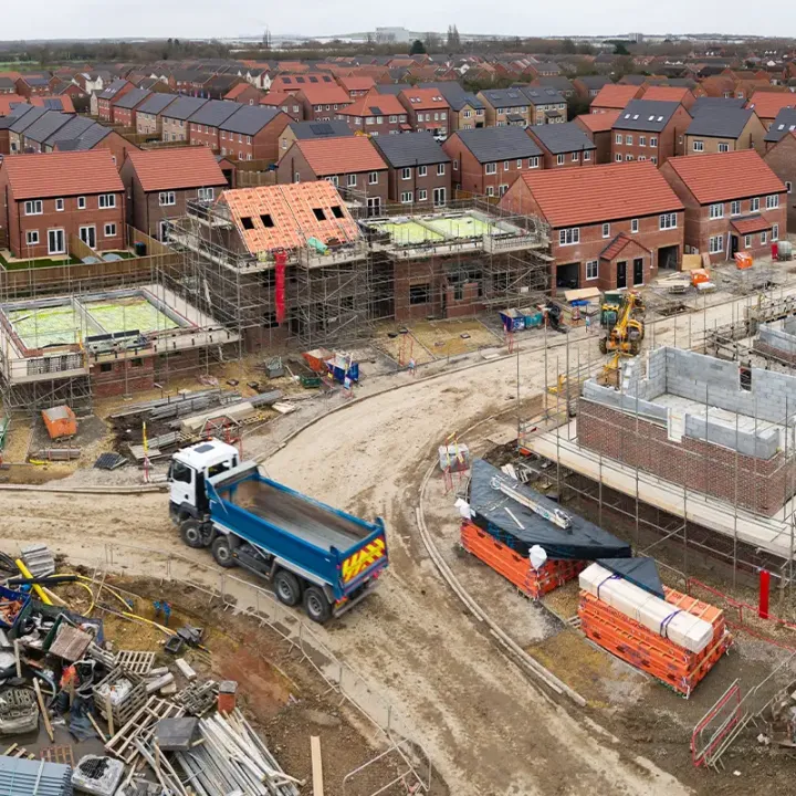 Housing development under construction with foundations, scaffolding and new roads